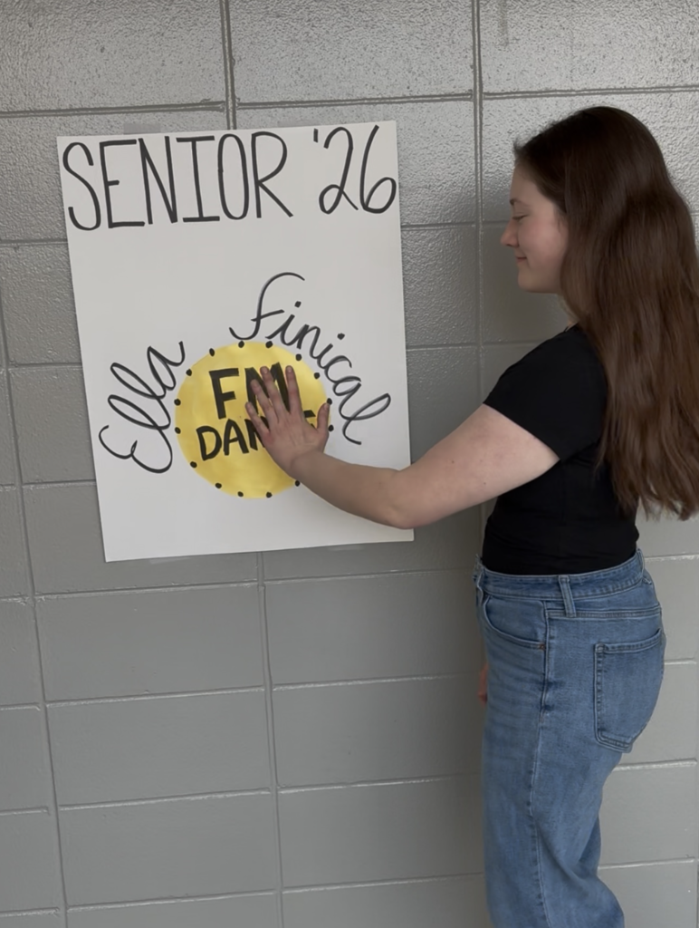 Student putting up a poster in the school