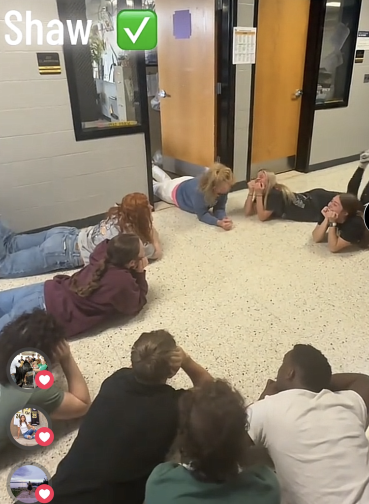 Students laying on the ground in the hallway for a video