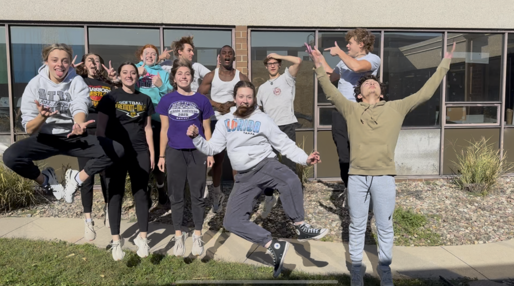 students jumping and posing for photo outside