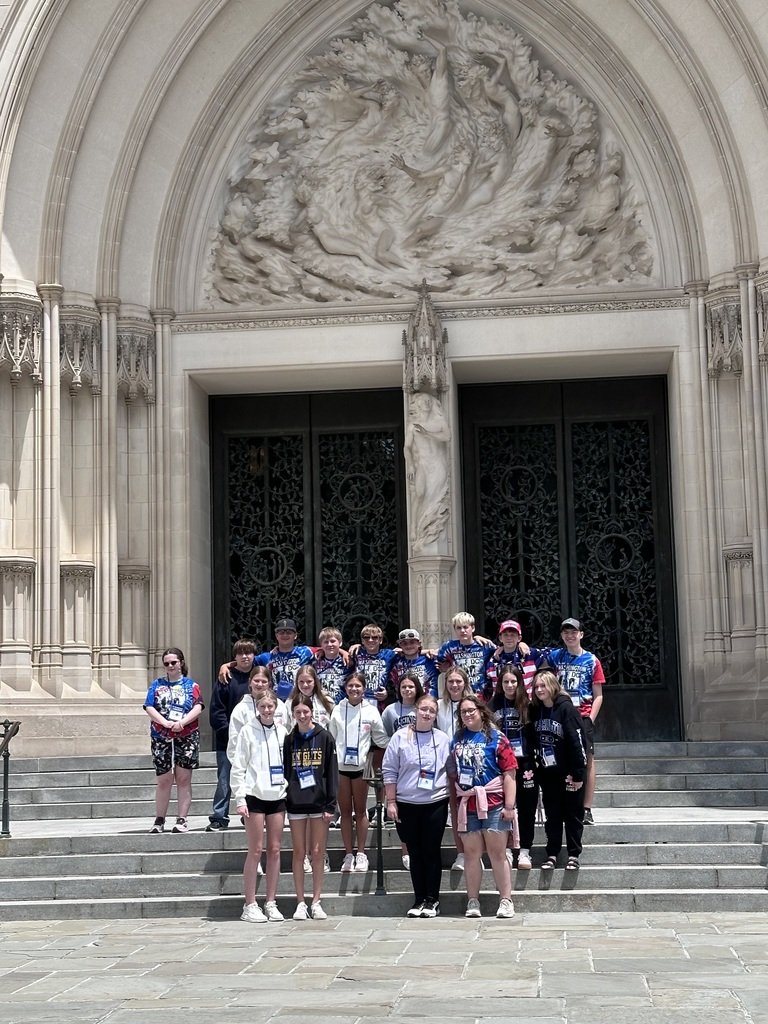 Students smiling in front of beautiful church door