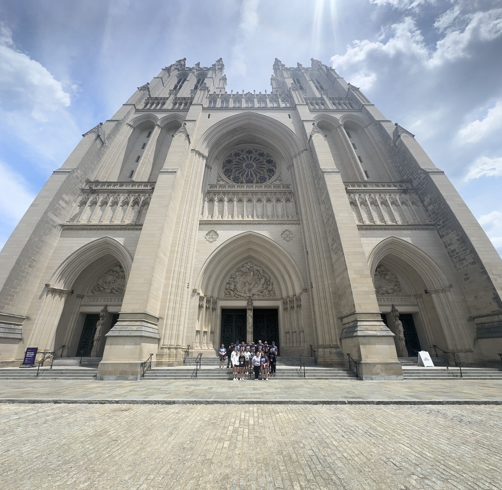Students posing in front of a beautiful church building
