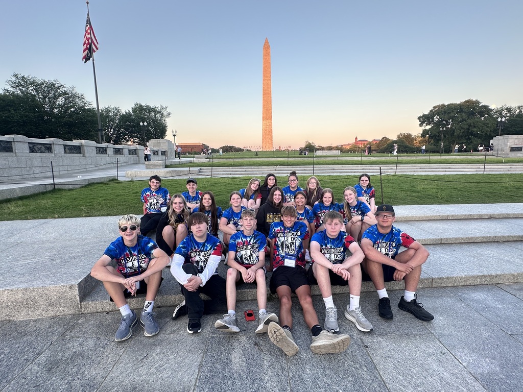 Students posing in front of monument
