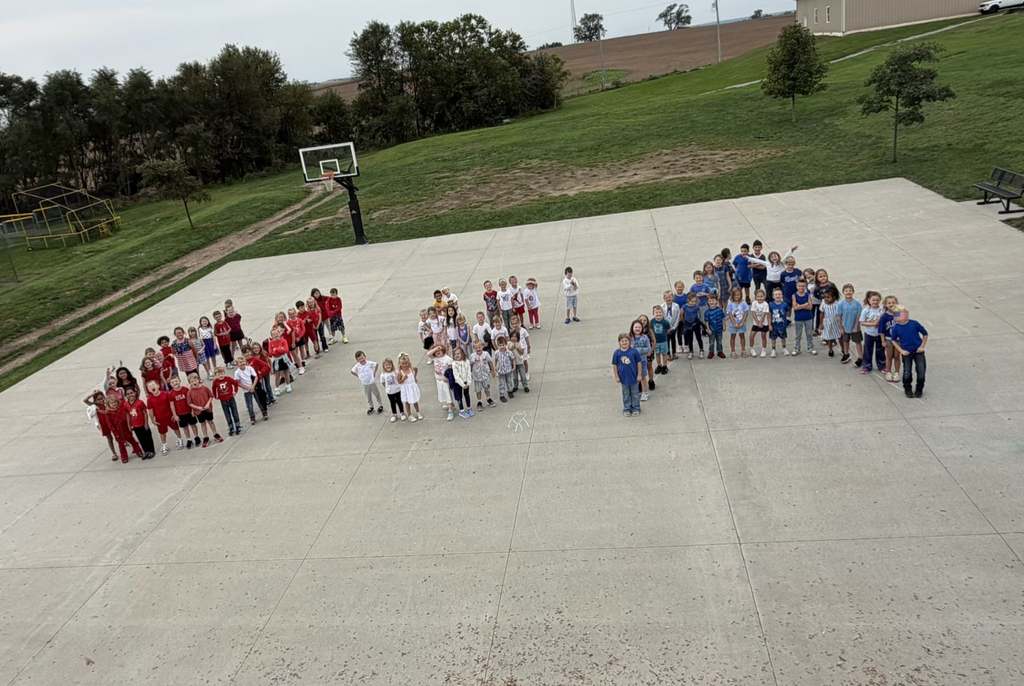 Students wearing red, white, and blue standing to form the letters USA