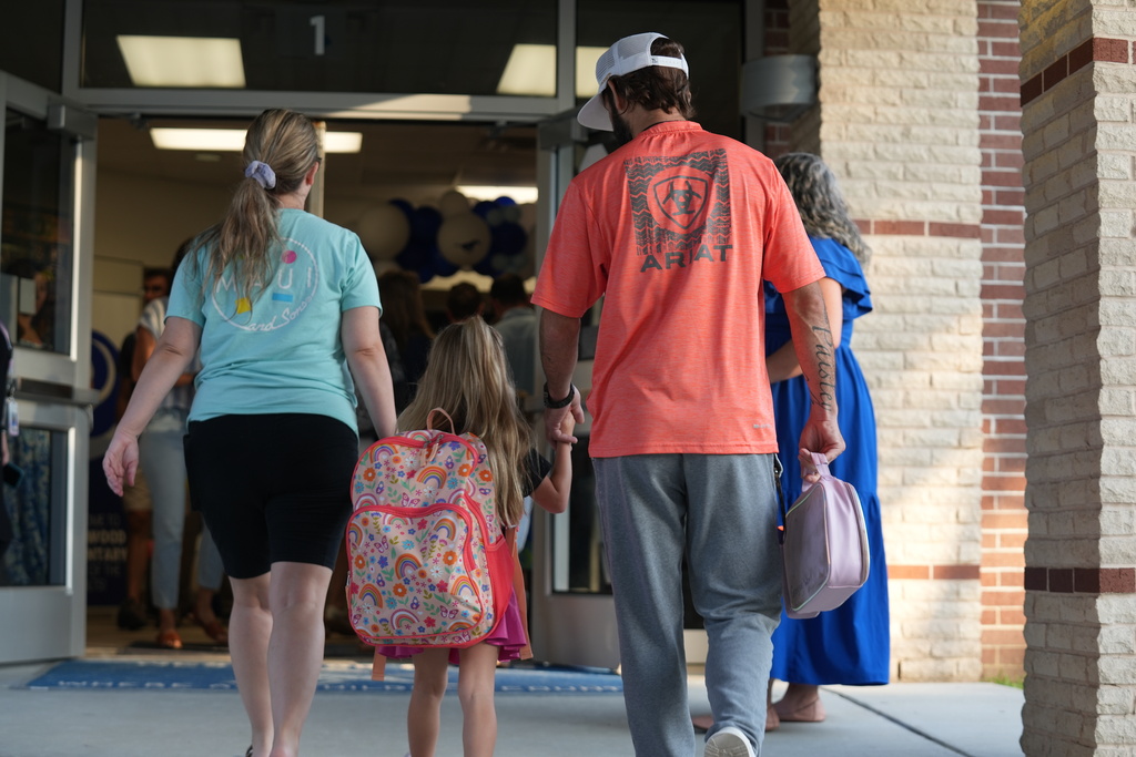 parents walking child into the school