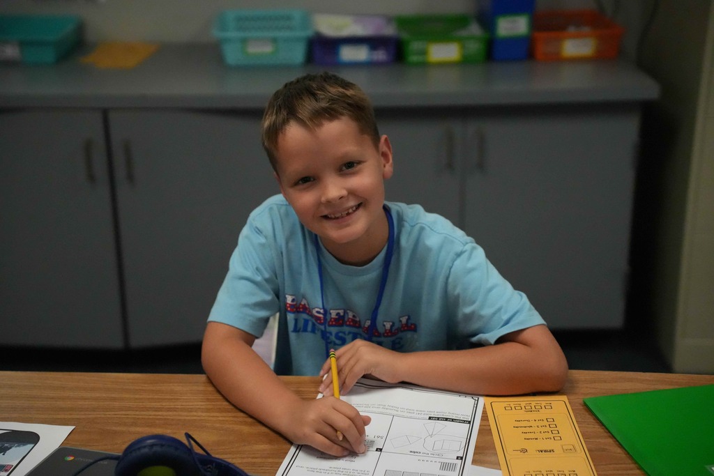 Boy smiling while working on worksheet