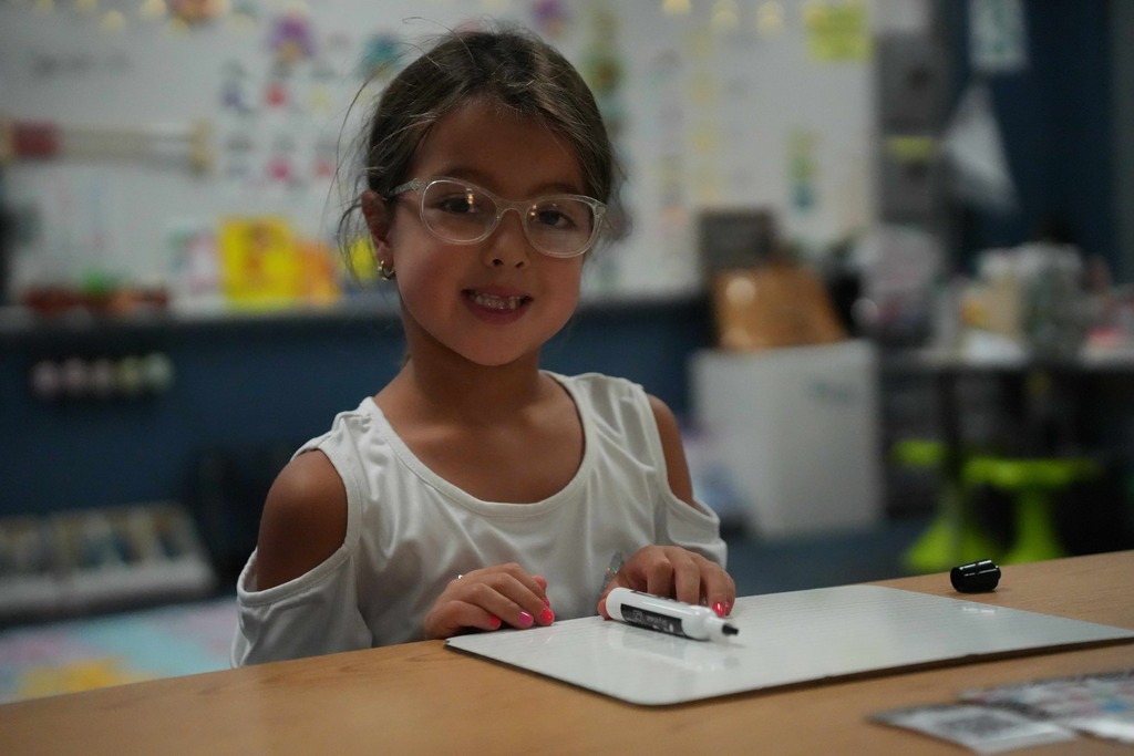 Girl smiling while working on whiteboard