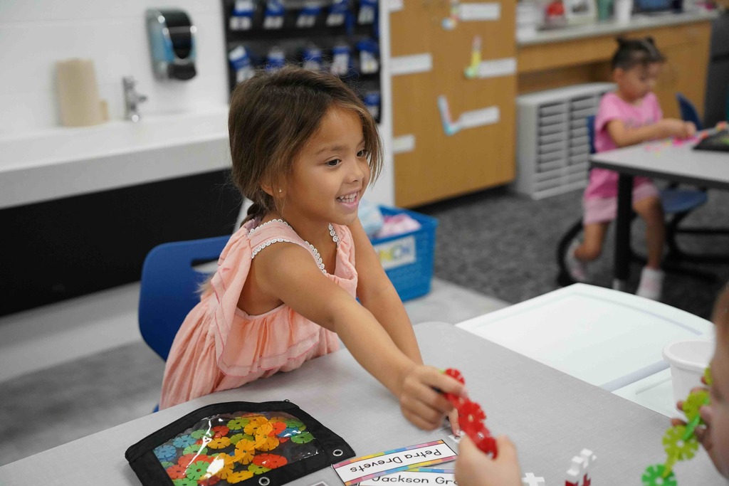 girl handing a toy
