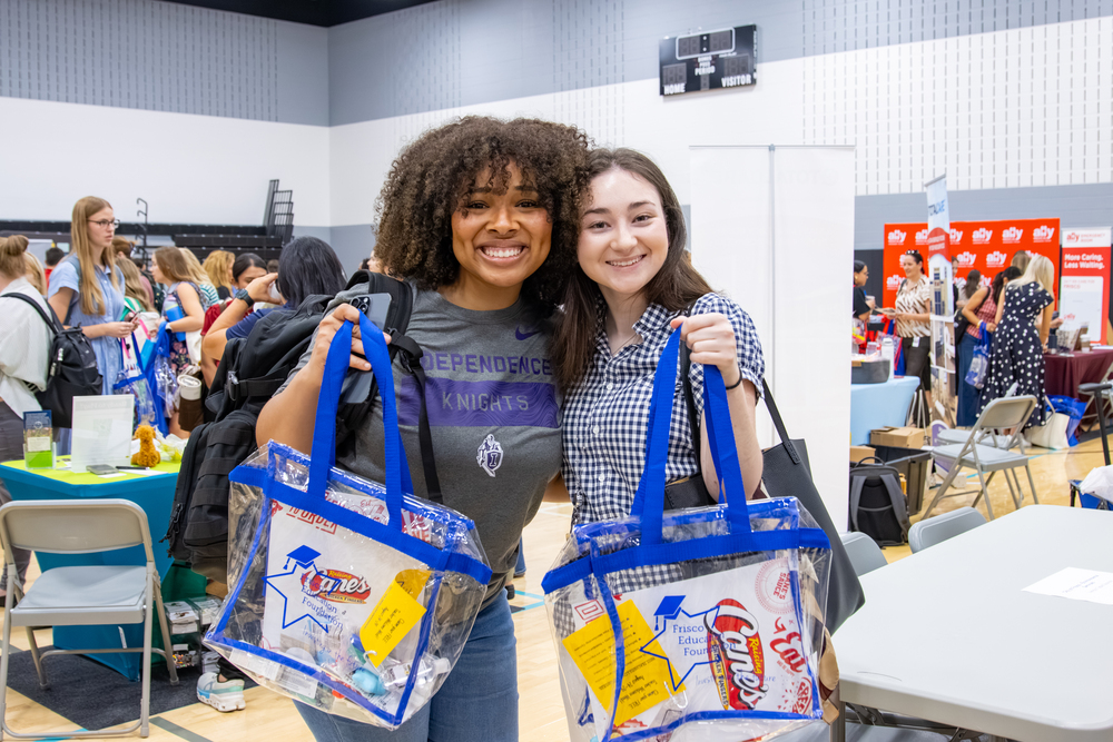 Two teachers holding welcome bags
