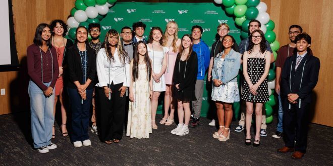 Students standing in front of a UNT background