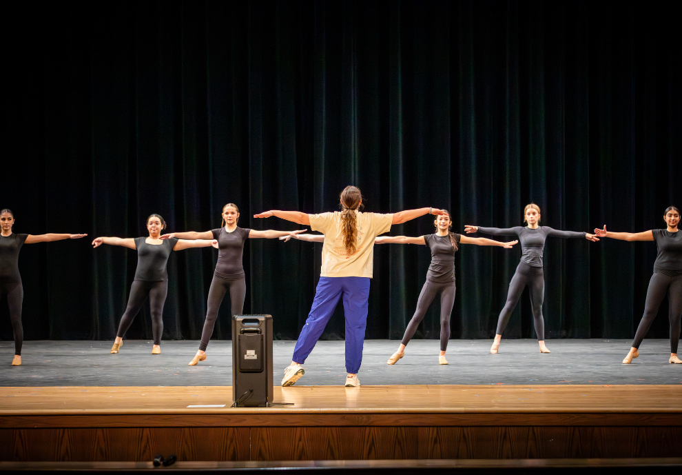 Dance students practice with their director