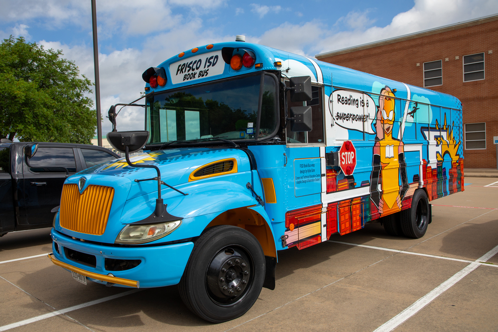 The Frisco ISD Book Bus is wrapped with a bright blue superhero-themed design
