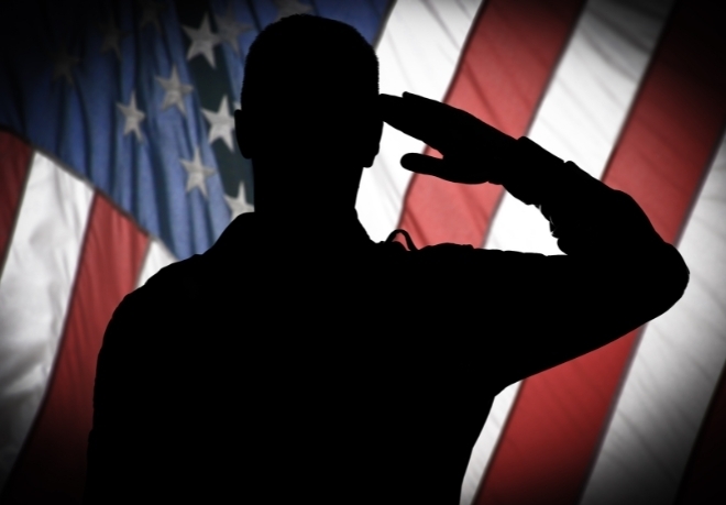 Man saluting in front of an American flag