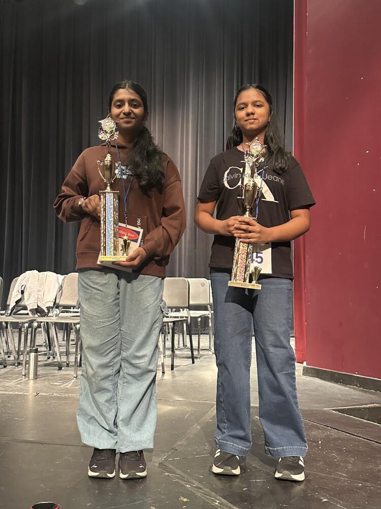 Two students holding trophies