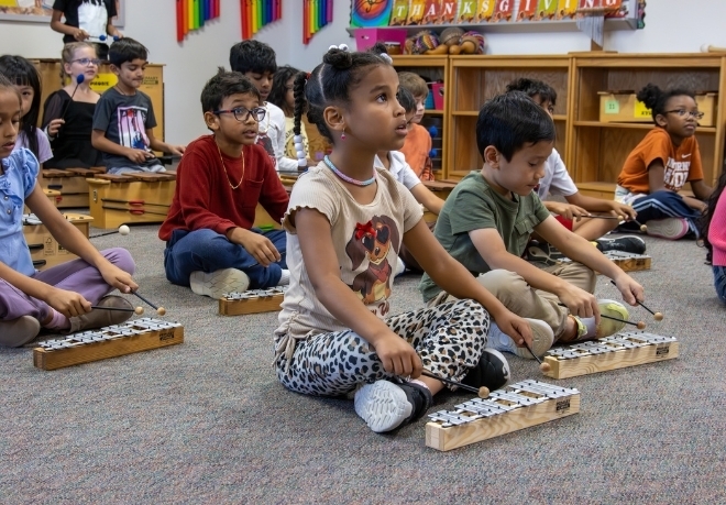 Young students play xylophones in class