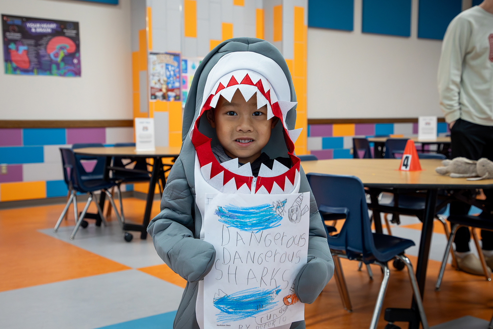 A student dressed as a shark shows off his story