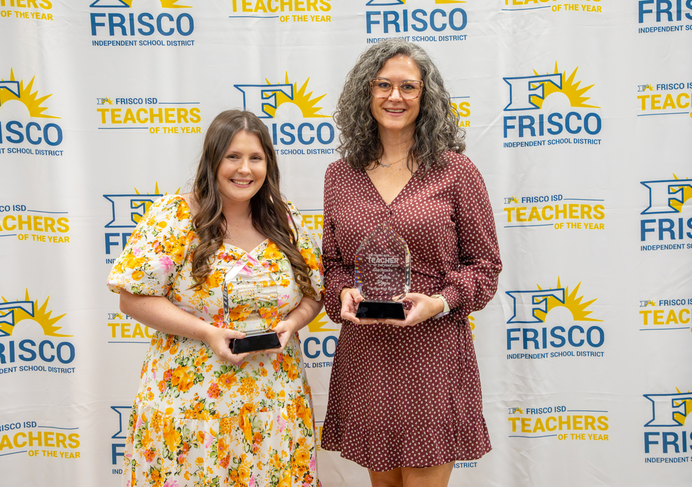 Two women holding awards
