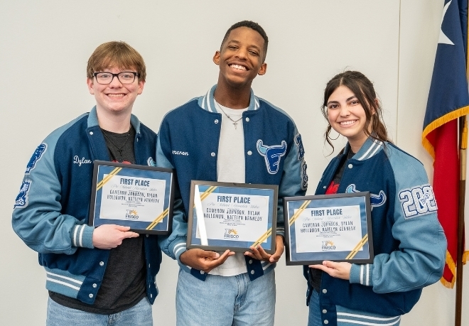 Three students holding certificates