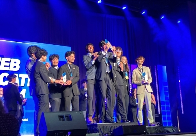 Students celebrating and holding a trophy