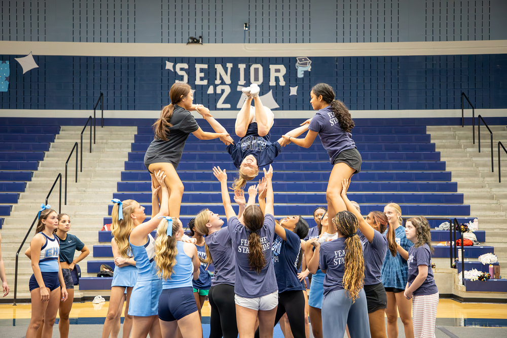 Cheerleaders perform a stunt.