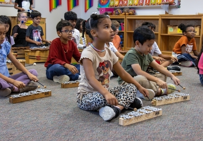 Young students play xylophones in class