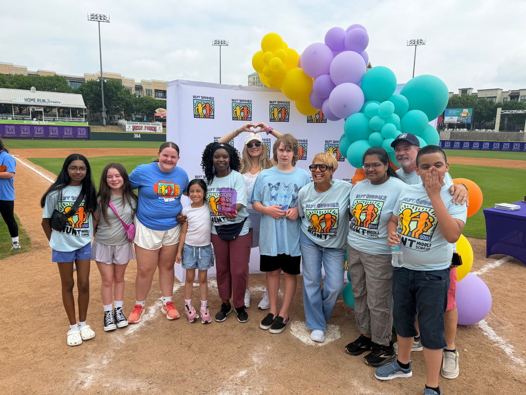 Hunt Best Buddies group on a baseball field in front of a photo backdrop