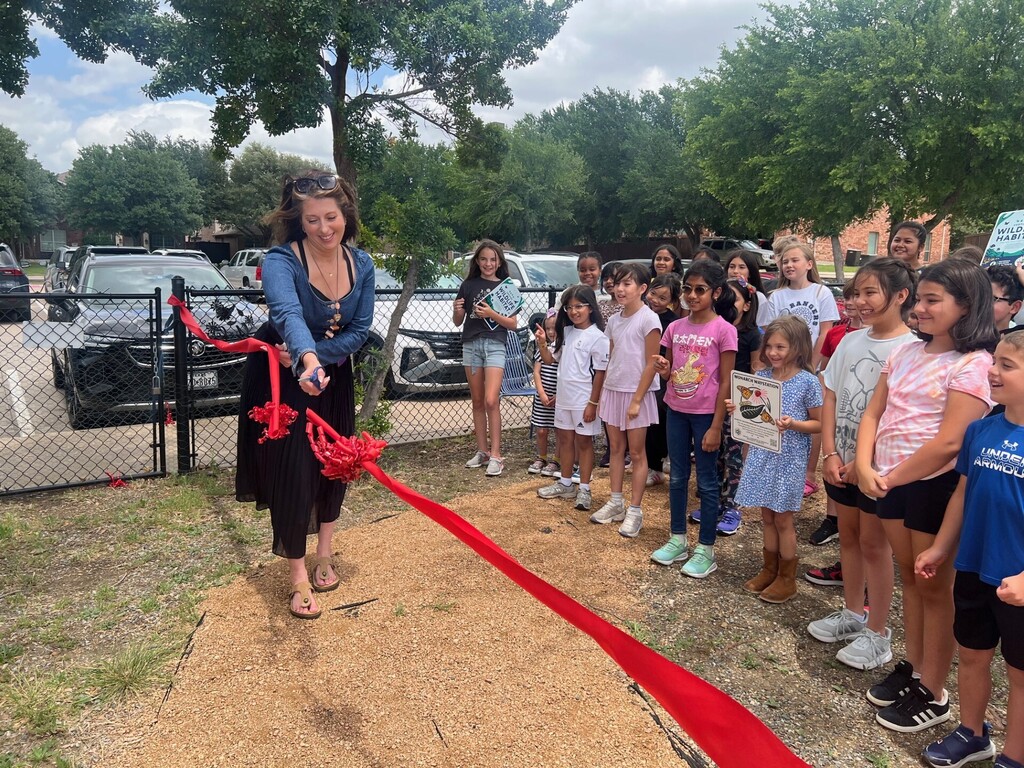 Boals teacher Elizabeth Uecker cuts the ribbon on the new wildlife habitat garden.