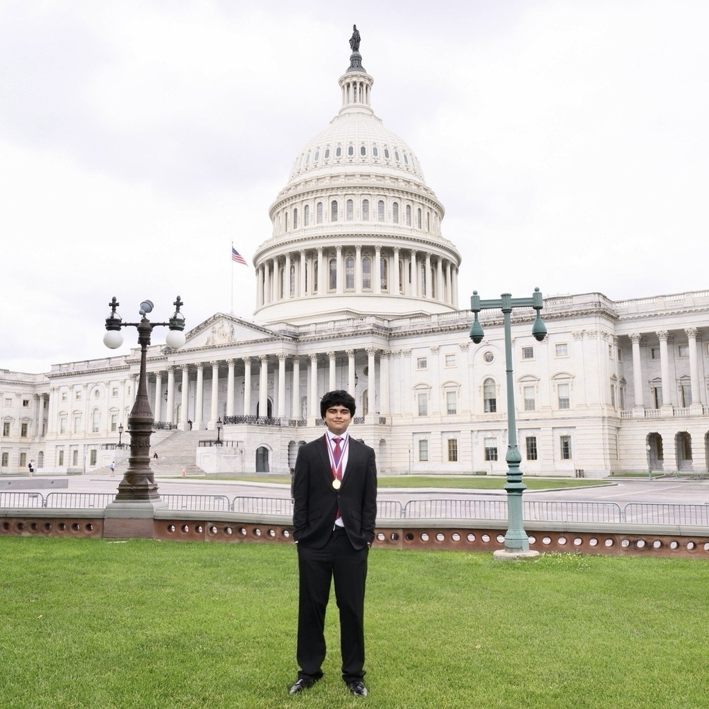 A boy in a suit standing in front of Congress
