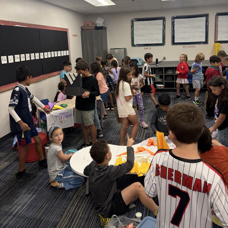Second graders presenting projects at an economics fair.