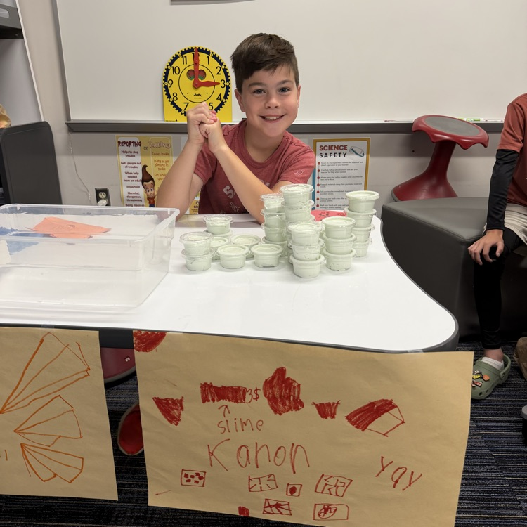 Second graders presenting projects at an economics fair.