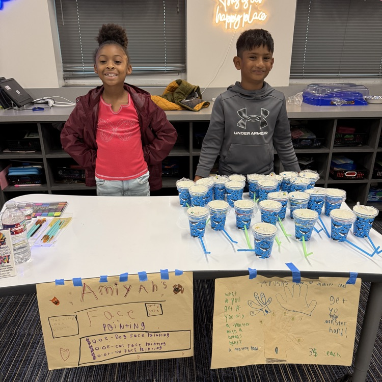 Second graders presenting projects at an economics fair.
