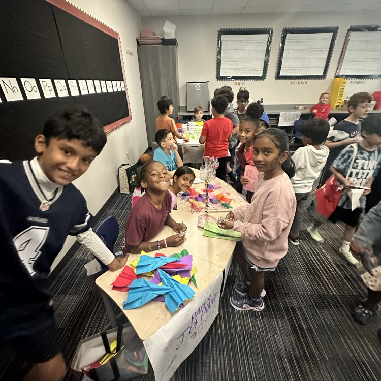 Second graders presenting projects at an economics fair.