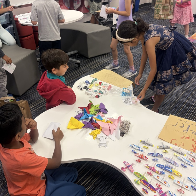 Second graders presenting projects at an economics fair.