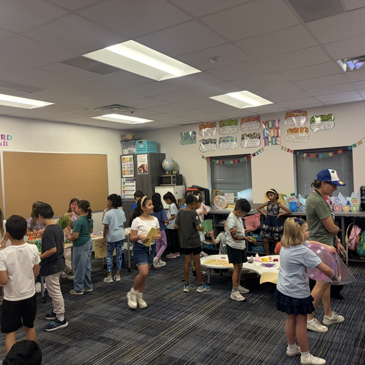 Second graders presenting projects at an economics fair.
