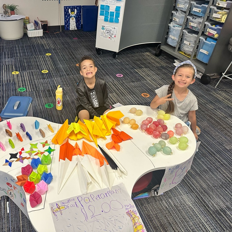Second graders presenting projects at an economics fair.