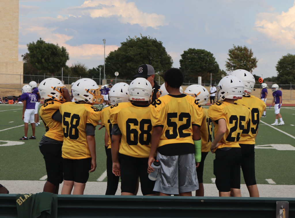 football players in a team huddle between plays