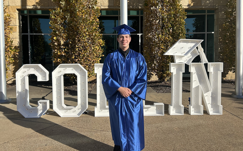 Male student holding a degree