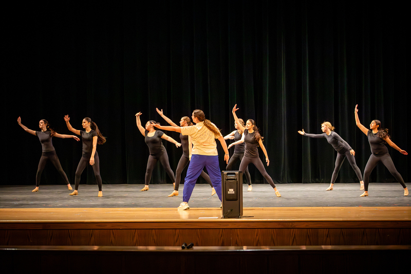 Dance students practice with their director