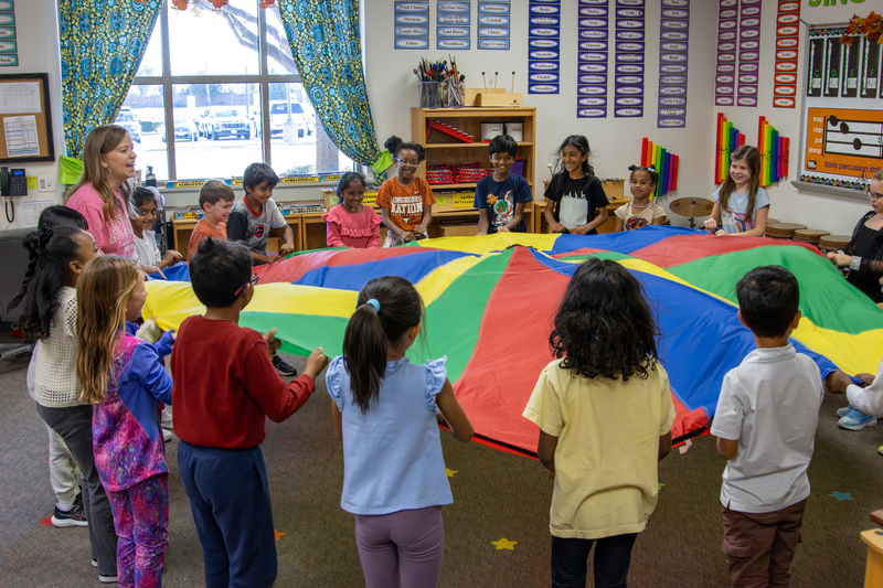 Students holding a round tarp in music class