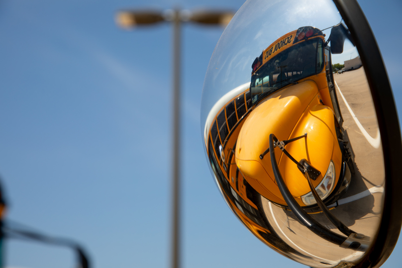 A bus is reflected in a side mirror