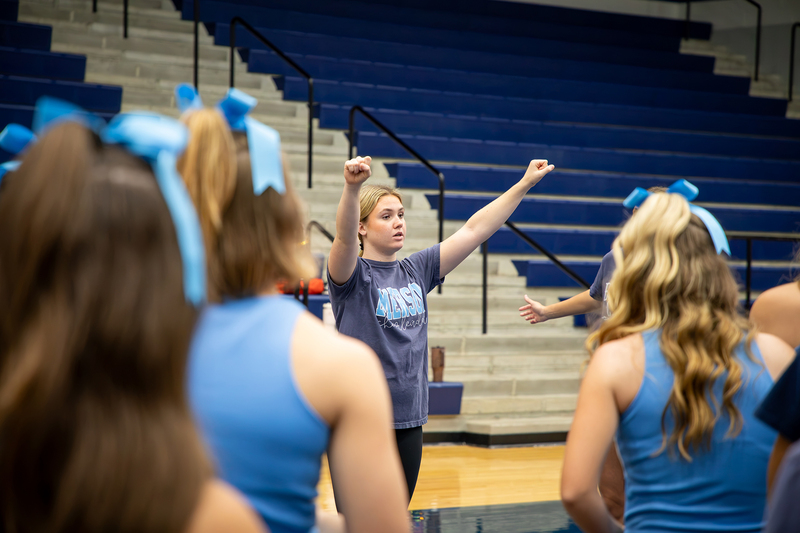 A cheer captain demonstrates a routine for her team.