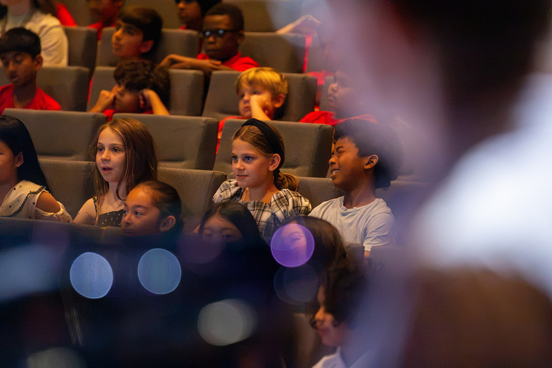 Several of Michal's students laugh along with the performance.