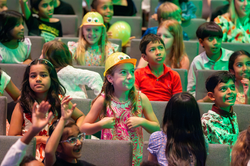 A girl smiles after receiving a duck hat from the performers.