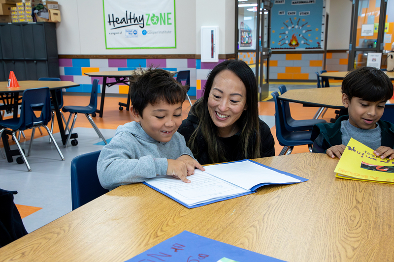 A parent with their student, who reads his story