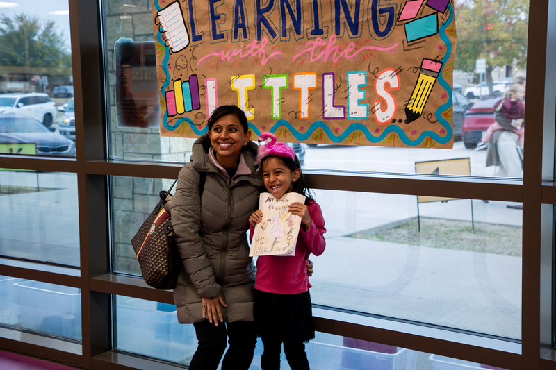 A parent with her student, who is dressed as a flamingo