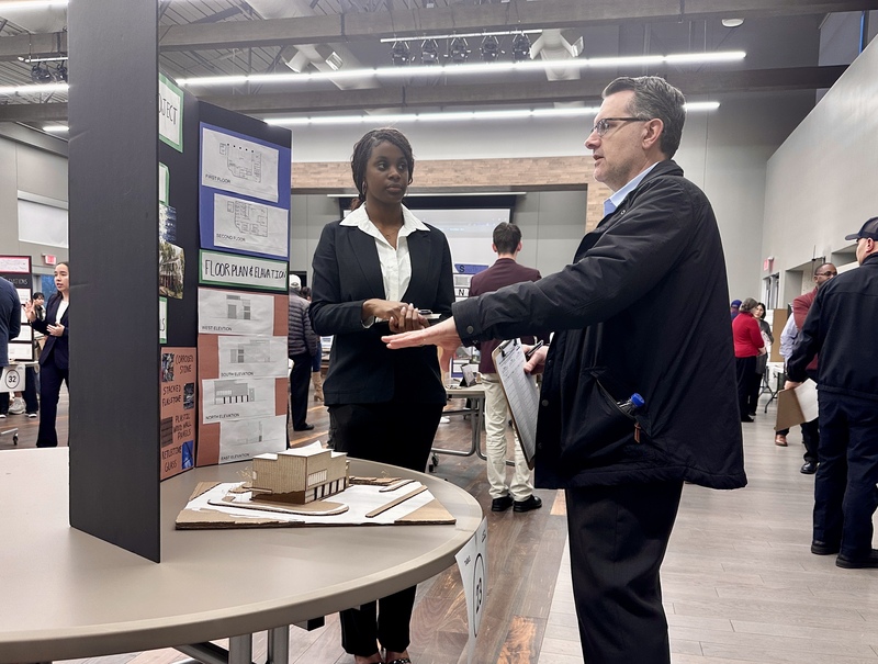 A student presents her project to an industry expert.