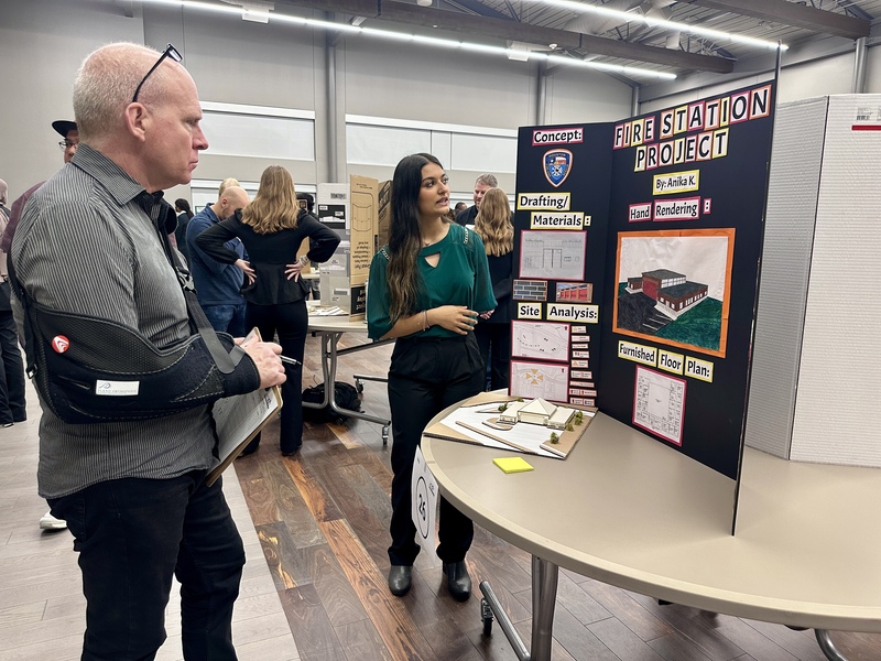 A student presents her project to an industry expert.