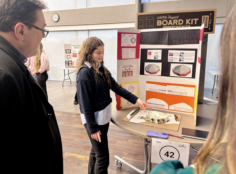 A student presents her project to an industry expert.