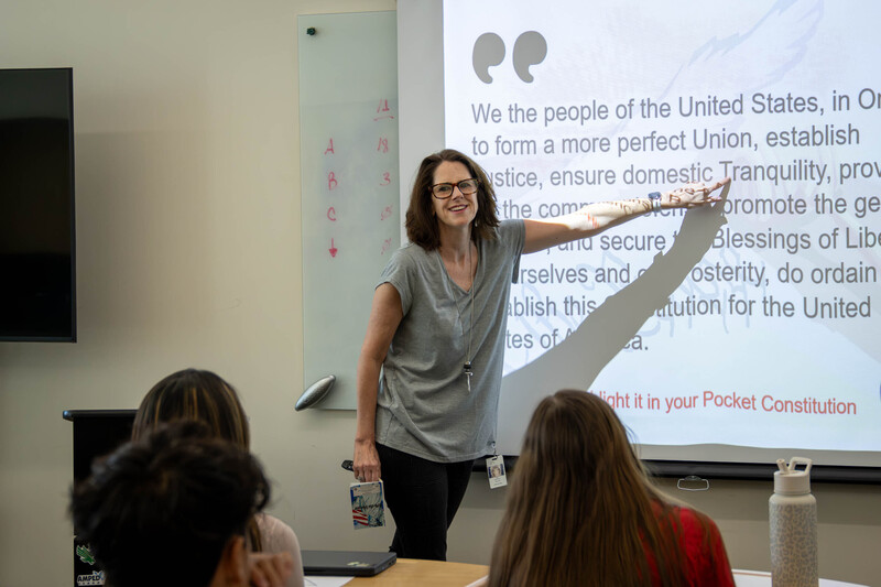 The government teacher points to a passage on the white board.