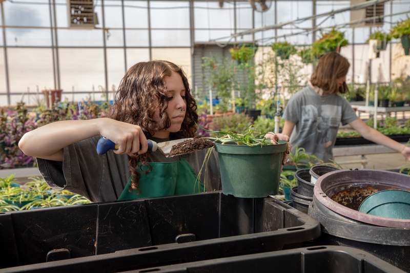A student pots a plant in the horticulture class.