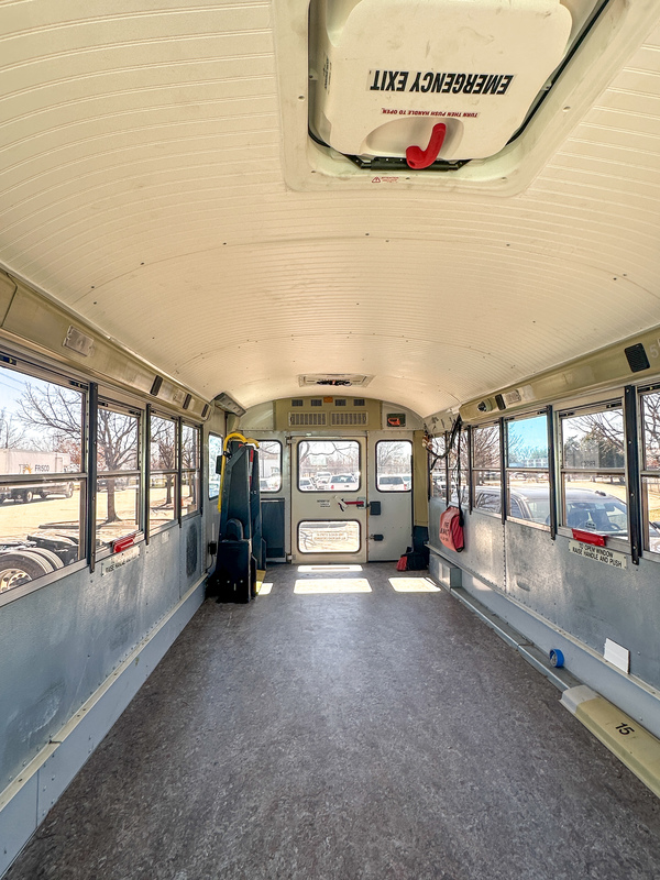 The inside of a refurbished school bus, with a new floor and ceiling